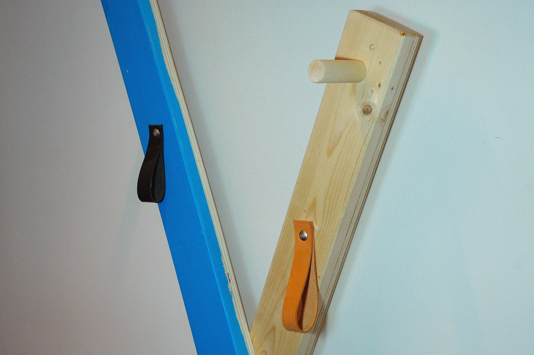 <alt="Cuir réemployé vissé sur un montant en bois, dans un système de patère Kozto">